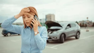 a woman on call infront of an accidented car